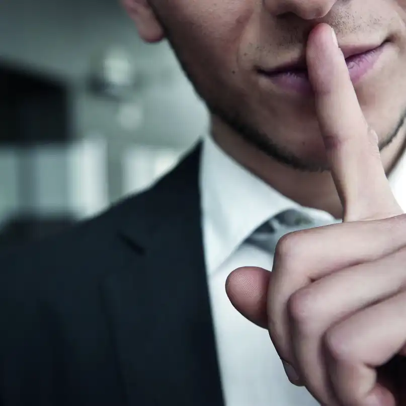 Ein Mann, der einen Zeigefinger vor den Mund hält