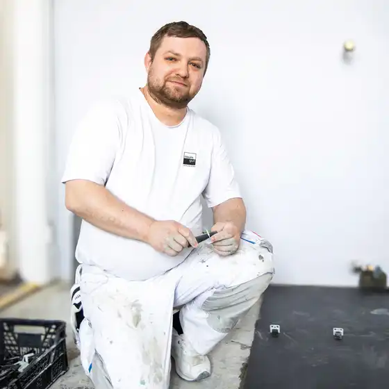 Ein Fliesenleger in Arbeitskleidung