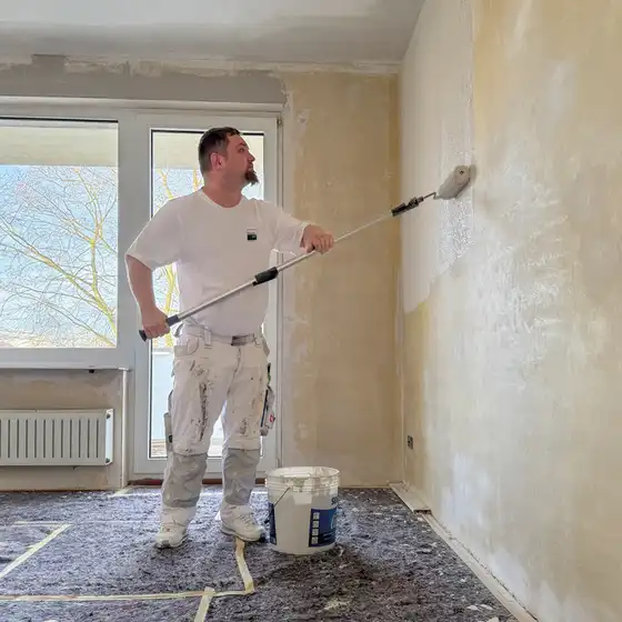 Ein Maler streicht eine Wand